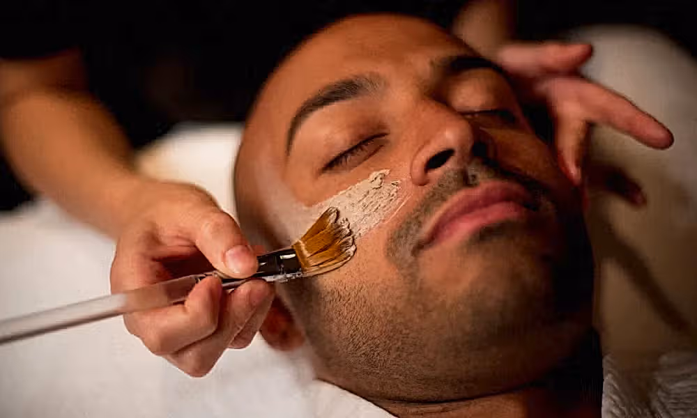 Mask being applied to man's face during facial