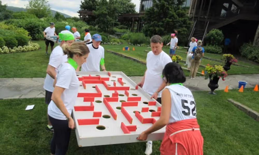 Adults helping each other in a teambuilding activity
