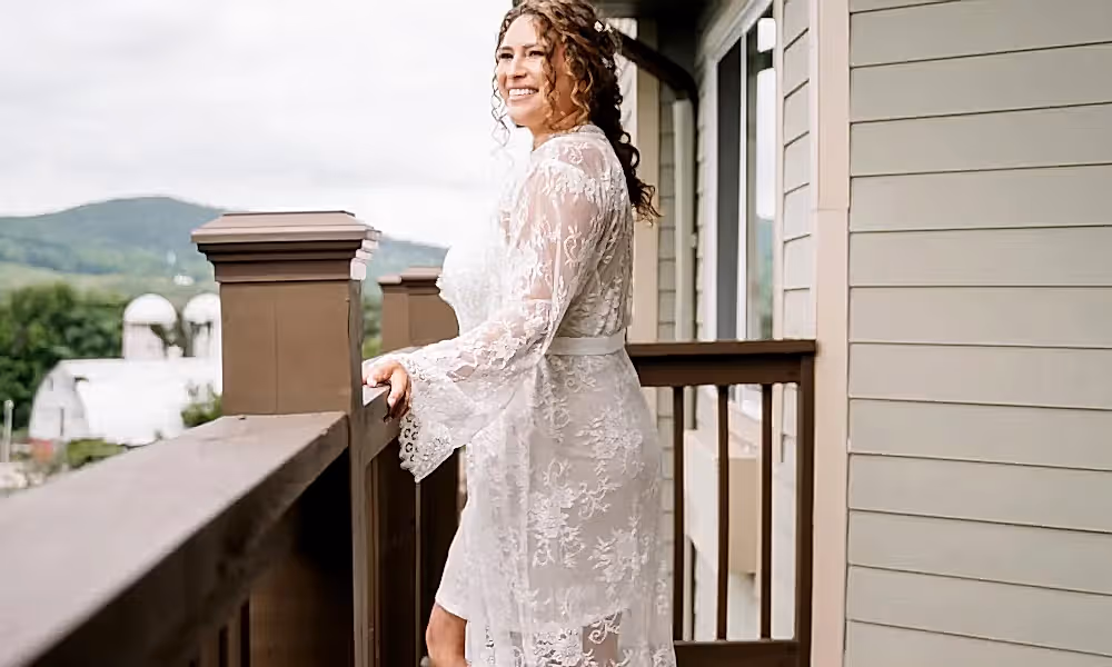 Beautiful bride in wedding dress standing looking over balcony